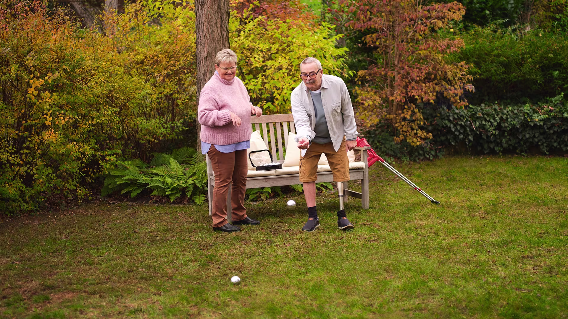An old man playing Boccia with his wife while wearing his Ottobock Kenevo.
