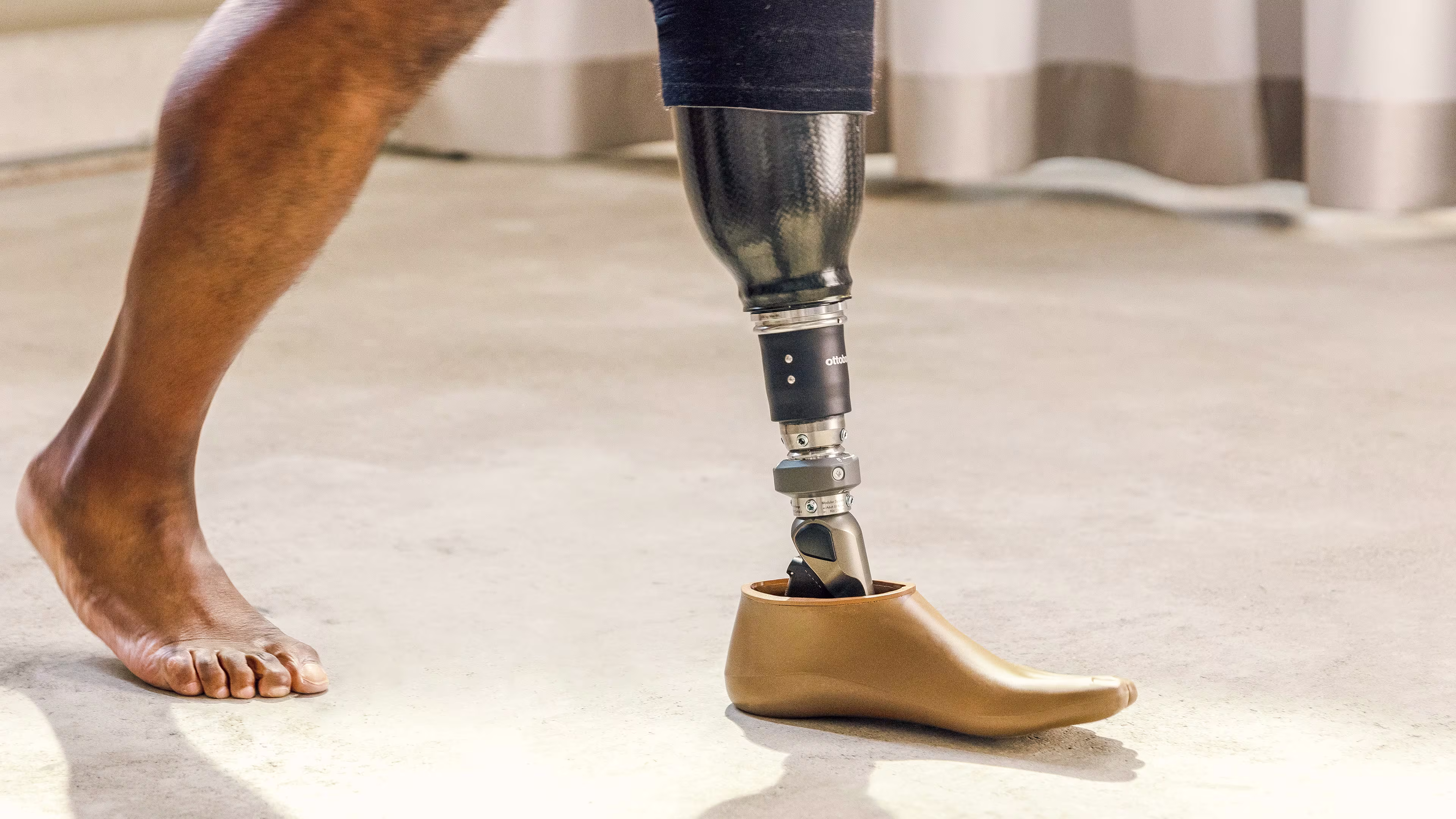 A man walking barefoot with the Taleo Adapt hydraulic prosthetic foot