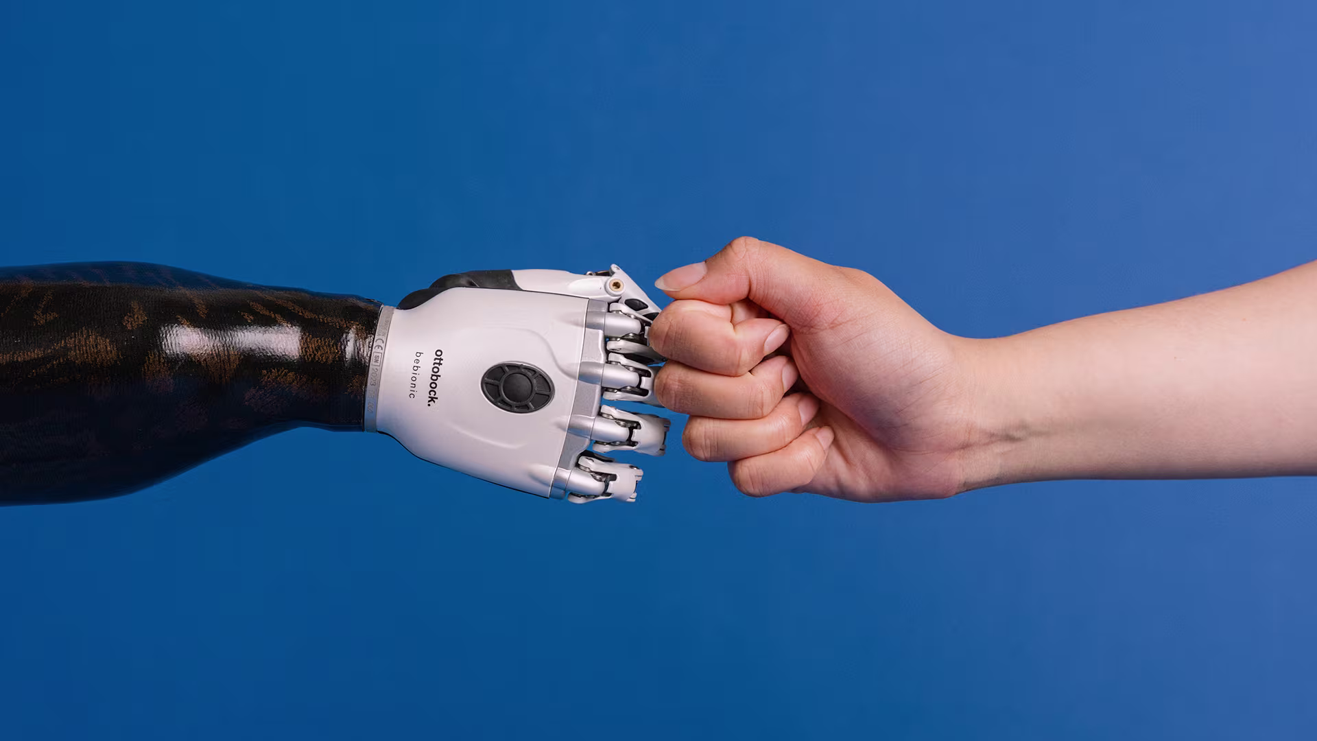 Ottobock bebionic multi-grip prosthetic hand giving a fist bump to a natural hand.