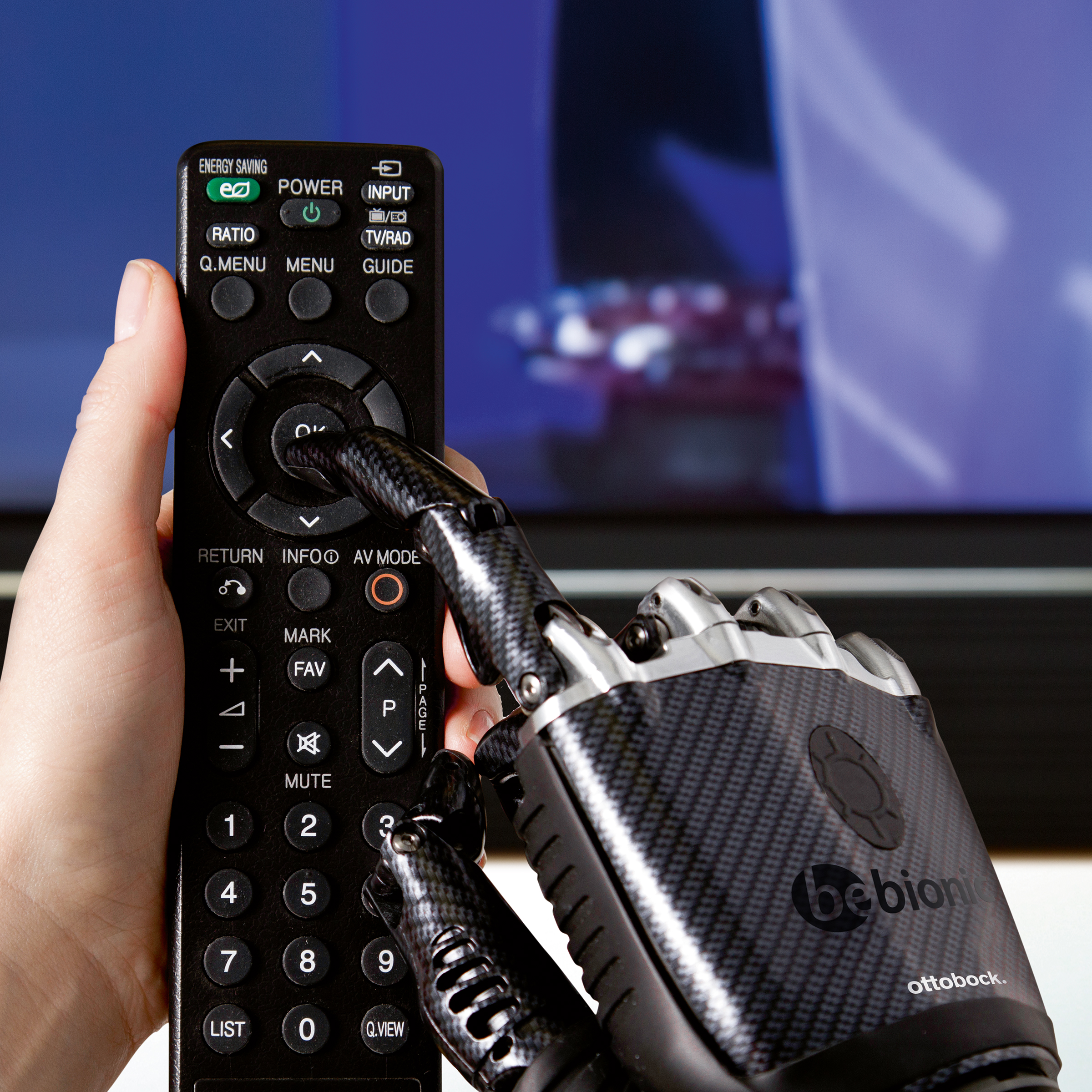 Zu sehen ist eine Fernbedienung, die von einer Prothetik Hand umfasst wird.