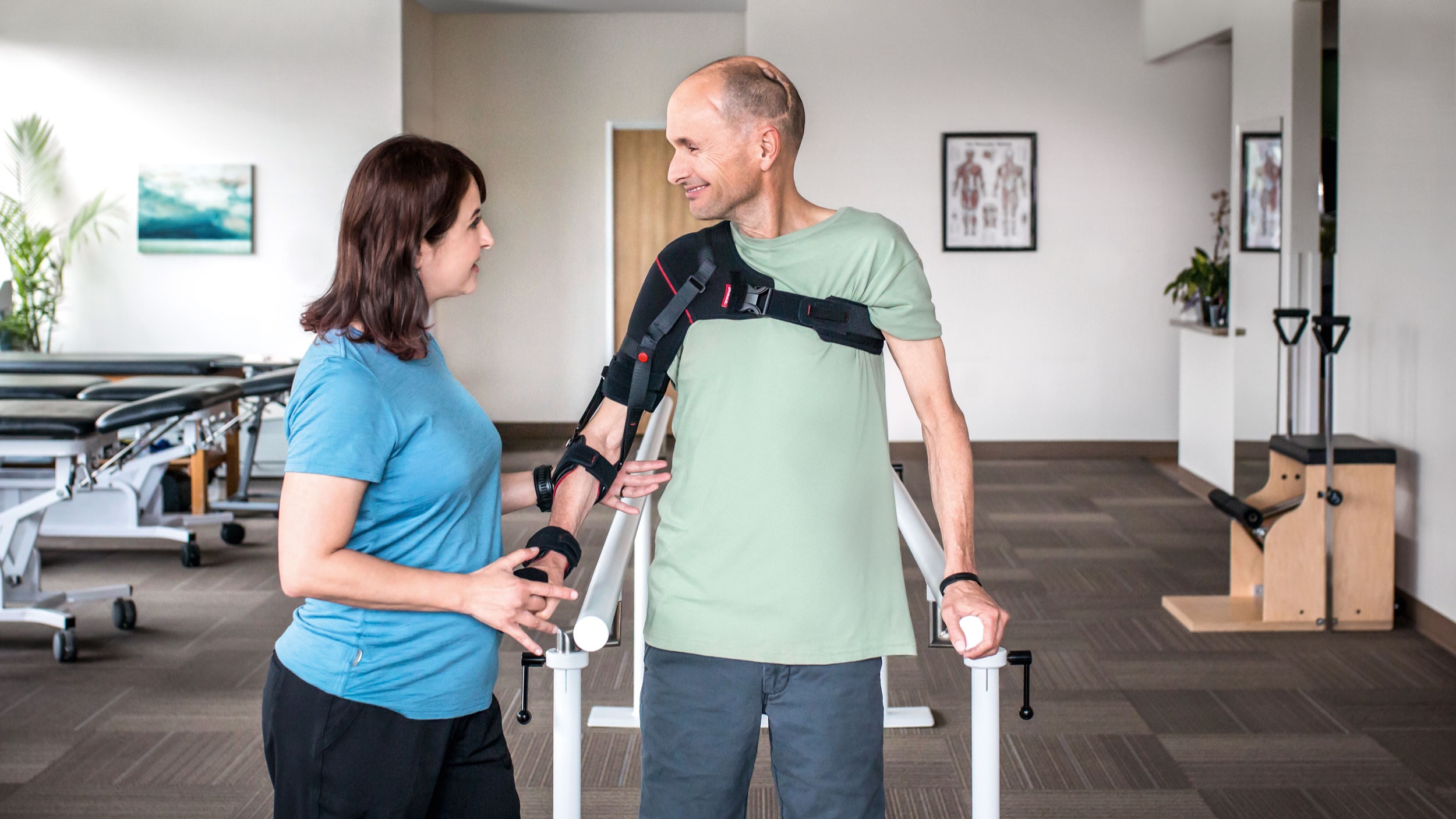 A man wearing an arm brace accompanied by a Certified Prosthetist Orthotist (CPO) in a clinic 