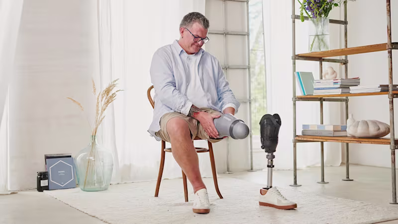 A transtibial amputee putting on his Skeo Sealing TT prosthetic liner