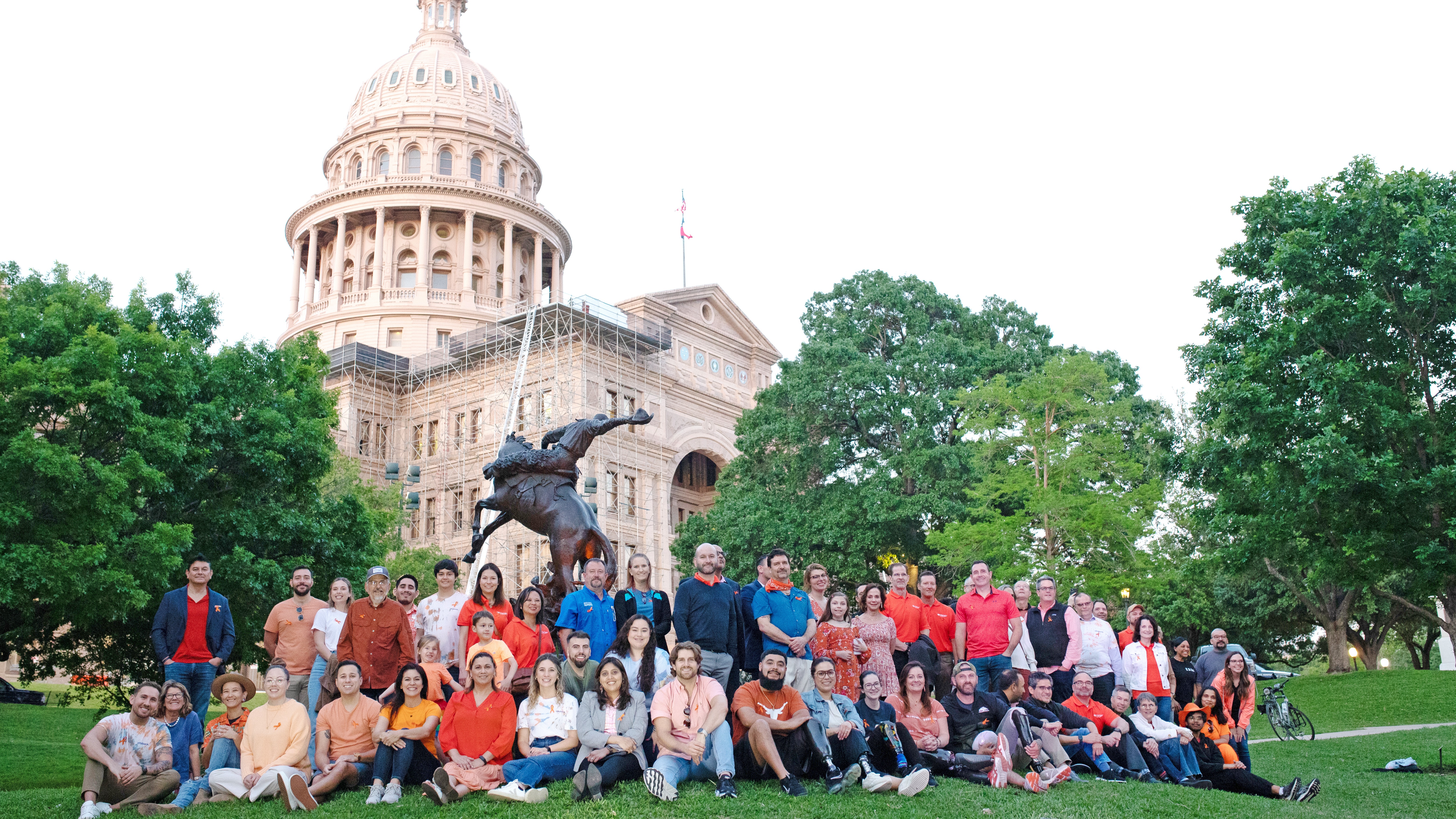 Various members of the limb difference community, accompanied by Ottobock team members, posing in front of the Texas State Capitol building 