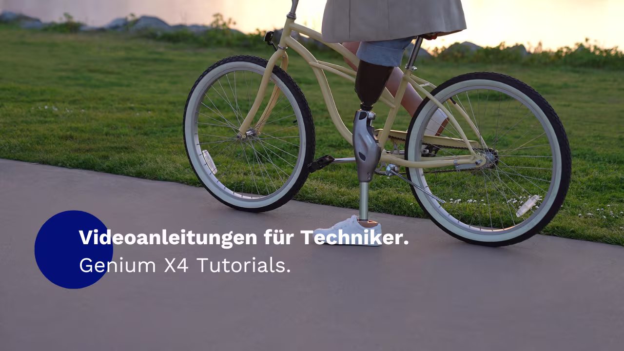 Auf einem Feldweg ist ein Fahrrad zu sehen. Der Bildausschnitt zeigt die untere Hälfte einer Person auf dem Fahrrad, die das mechatronische Kniegelenk Genium X4 von Ottobock trägt.