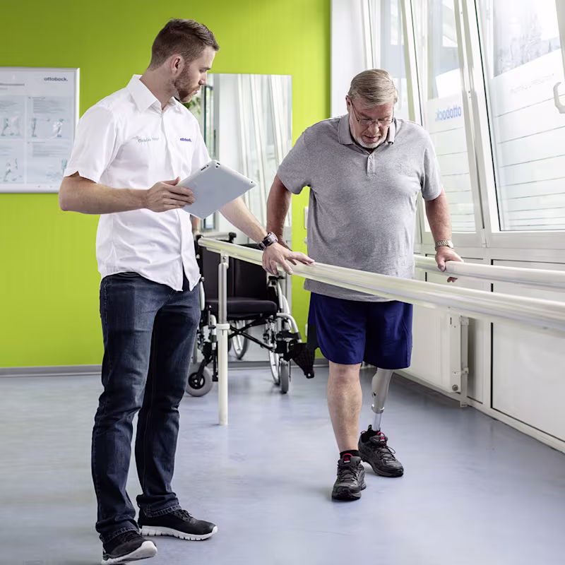 An O&P professional aids an amputee during their trial of a bionic foot