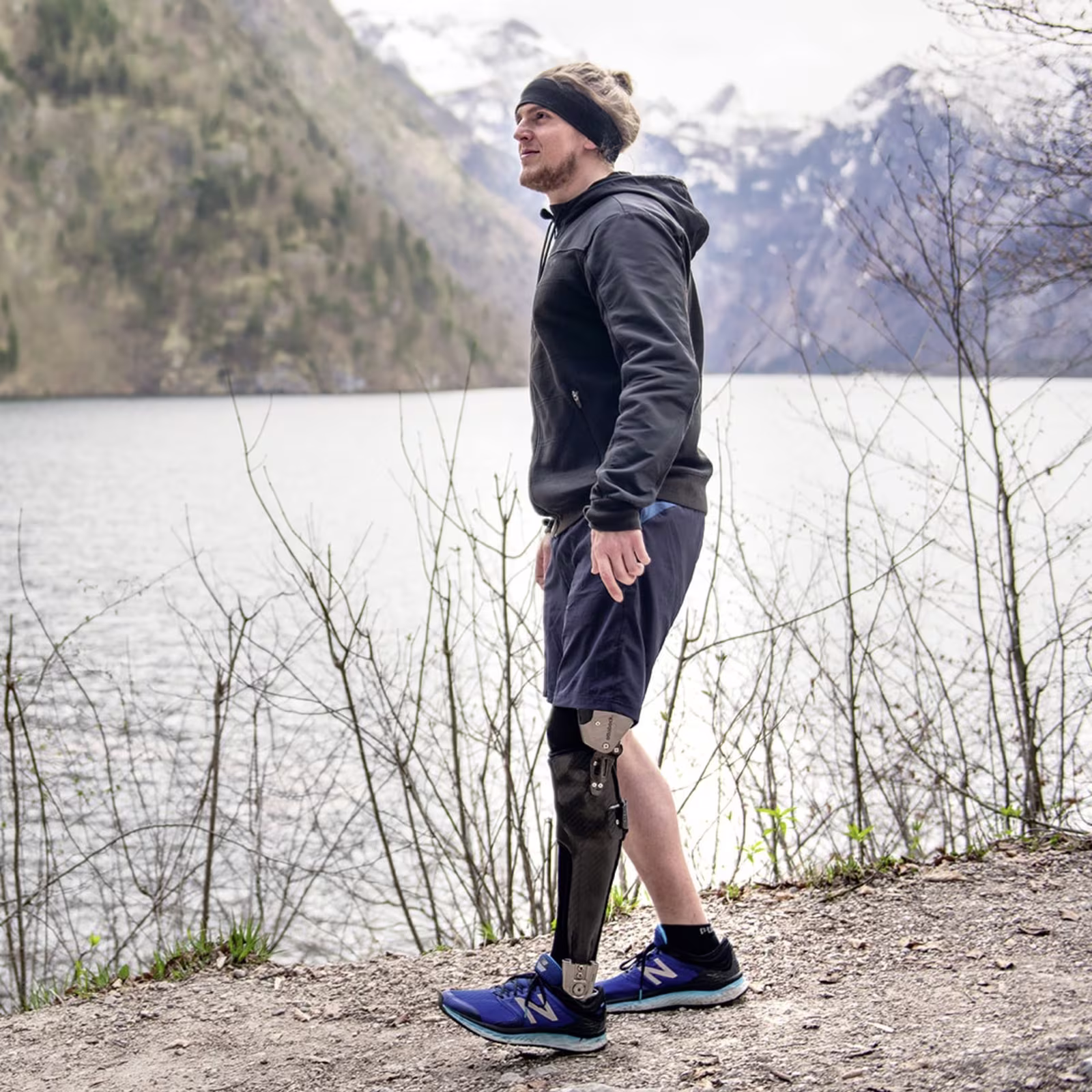 Anwender wandert mit dem C-Brace am Ufer eines Sees