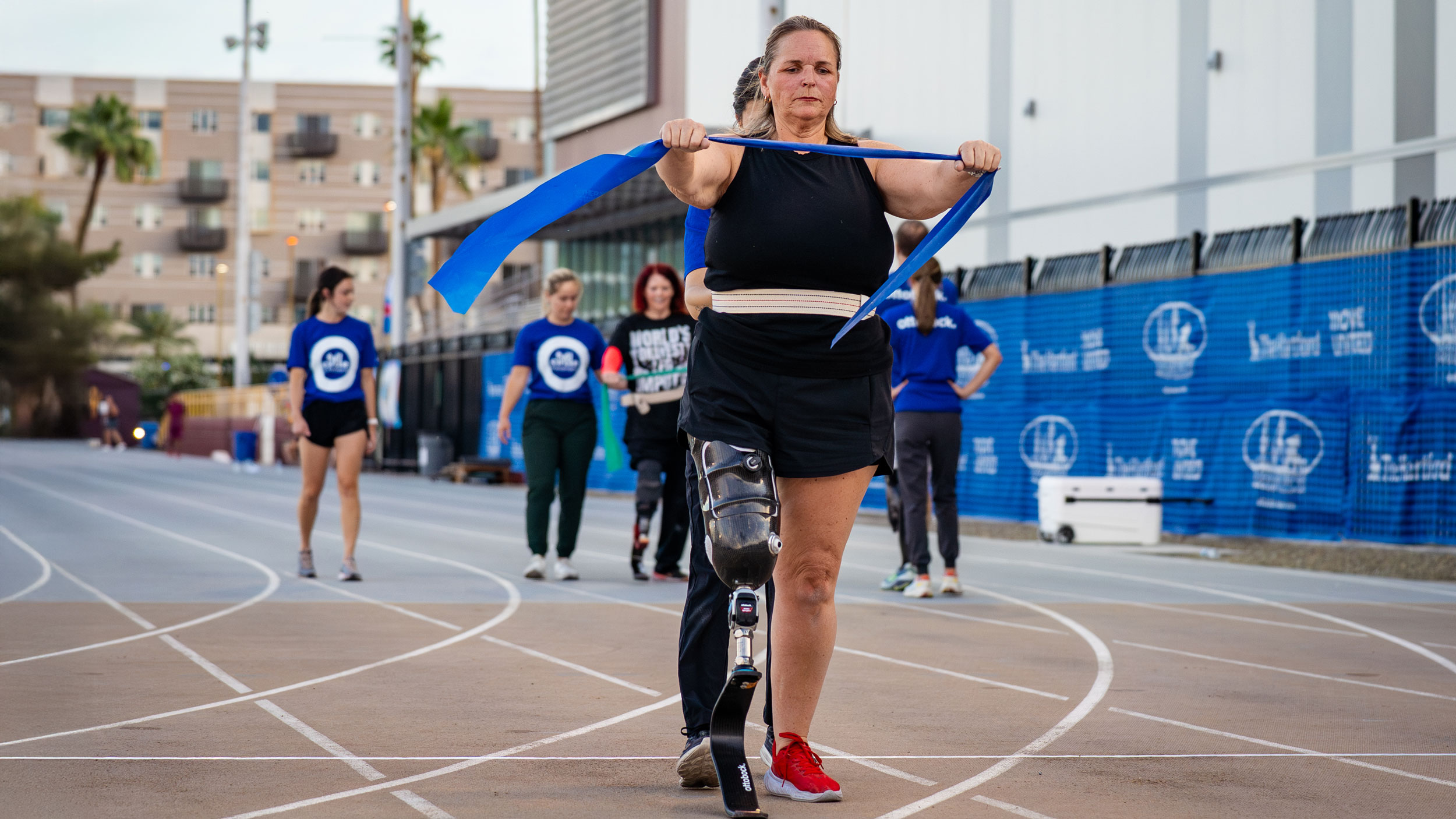 A prosthetic leg user stretching on a outdoor running track