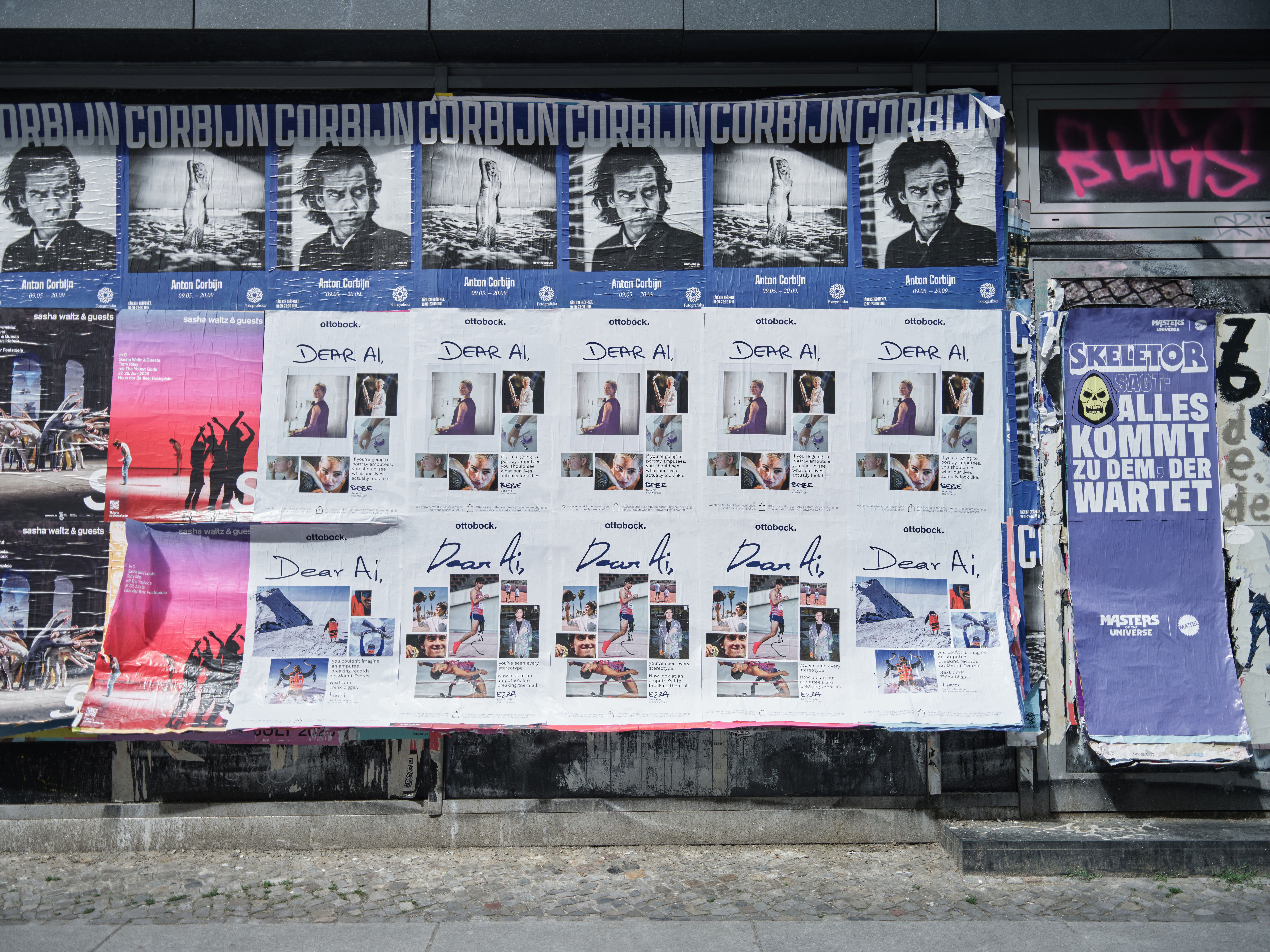 Mehrere Plakate der Ottobock Kampagne „Dear AI“ sind auf einer Berliner Plakatwand im urbanen Umfeld angebracht. Die Kampagne thematisiert Inklusion, Barrierefreiheit und die Darstellung von Menschen mit Behinderungen in Zeiten künstlicher Intelligenz. Umgeben von Kulturplakaten, Street Art und urbanen Elementen entsteht ein authentisches Bild moderner Außenwerbung im öffentlichen Raum.