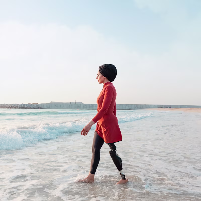A woman wears the Ottobock-manufactured C-Leg 4 while walking into the ocean