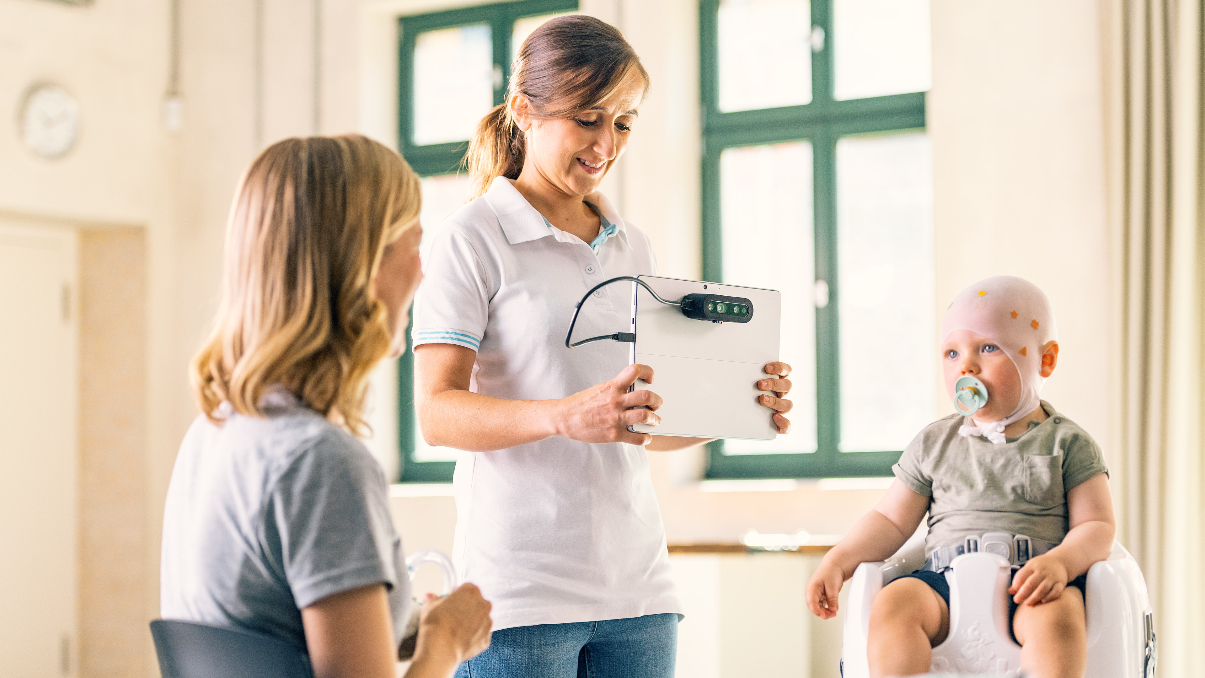 A pediatric doctor measuring a child's head for a cranial helmet fitting