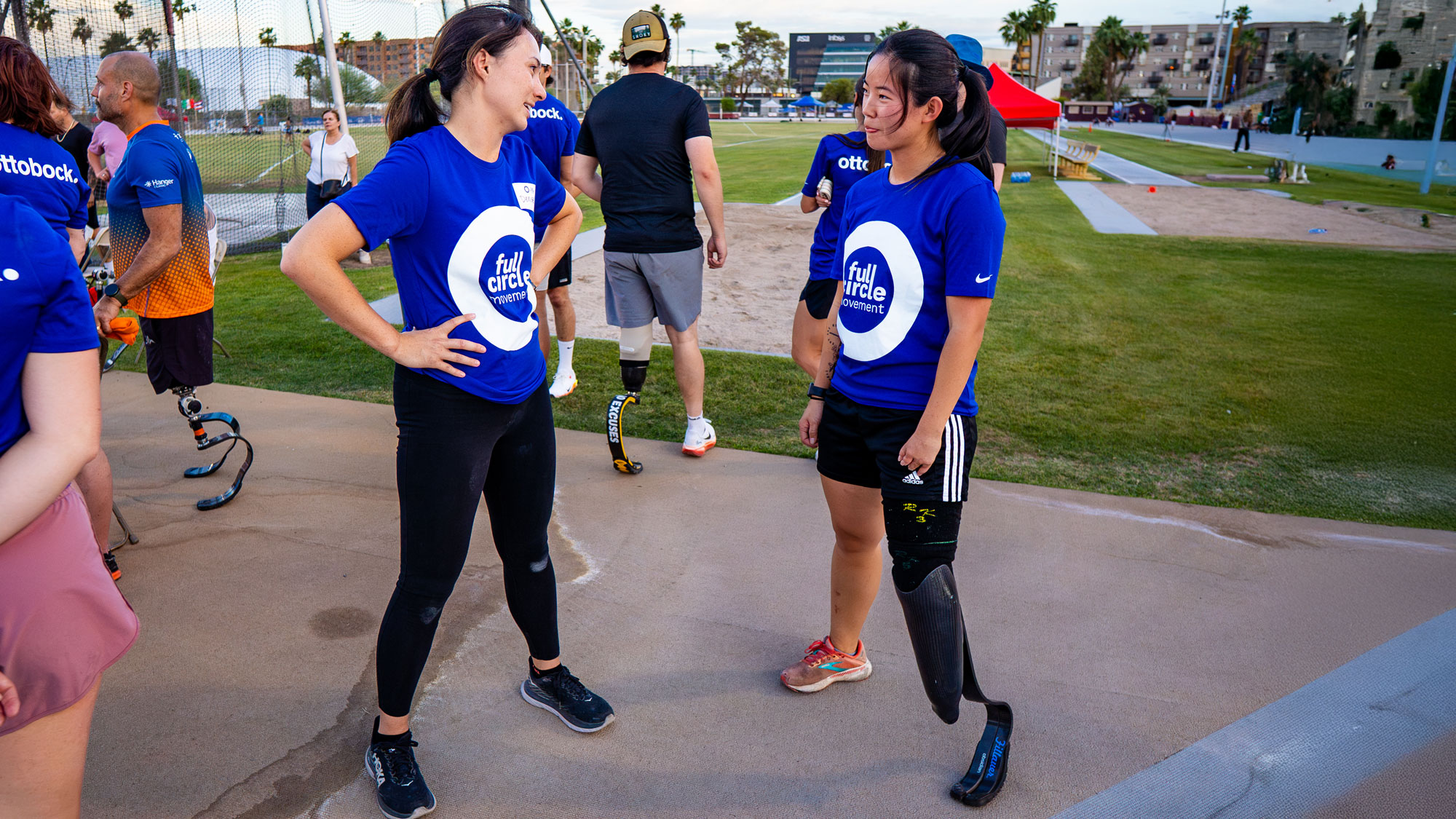 An event volunteer speaking with a prosthetic running blade user 