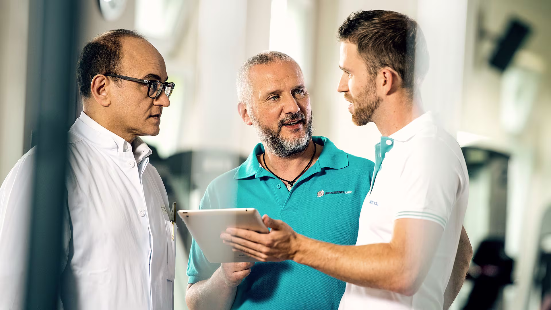 2 prosthetists discussing with a doctor while one is holding a tablet