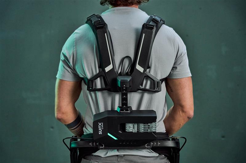 Auf dem Bild sieht man einen Mann der ein Ottobock Exoskelett in der Hand hält. 