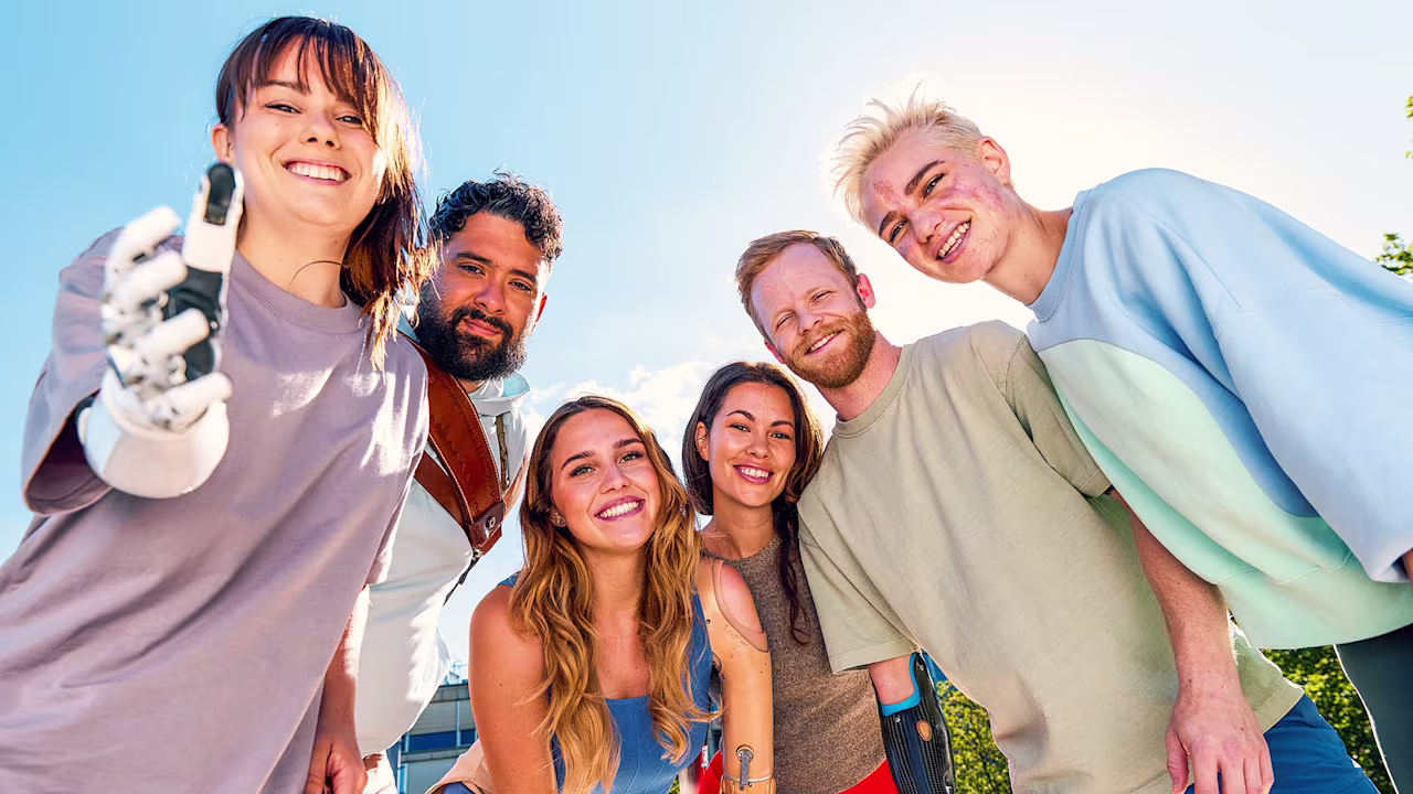 Prosthetic device users standing in a semi circle and posing for the camera
