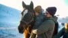 Patient med cerebral pares kramar om en häst med sin pappa