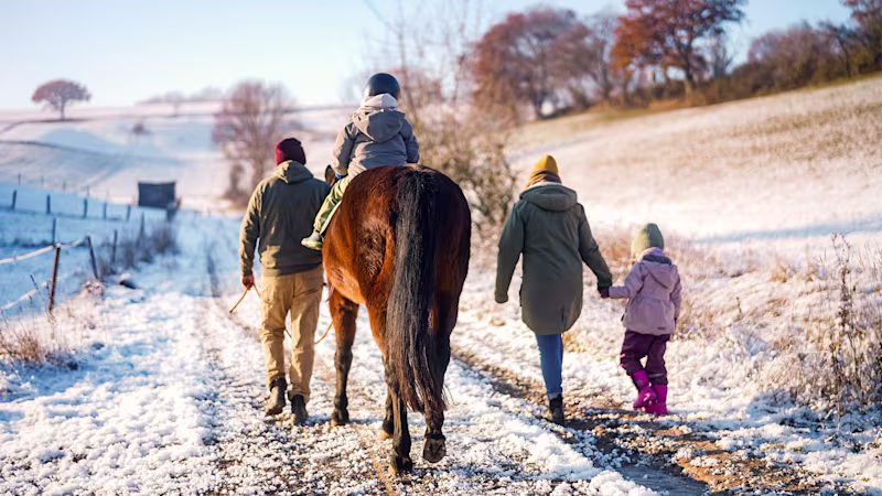Zerebralparese Patient sitzt auf einem Pferd und geht mit seiner Familie spazieren