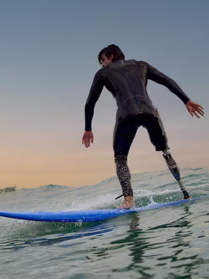 A Genium X4 microprocessor knee (MPK) user is surfing during sunset