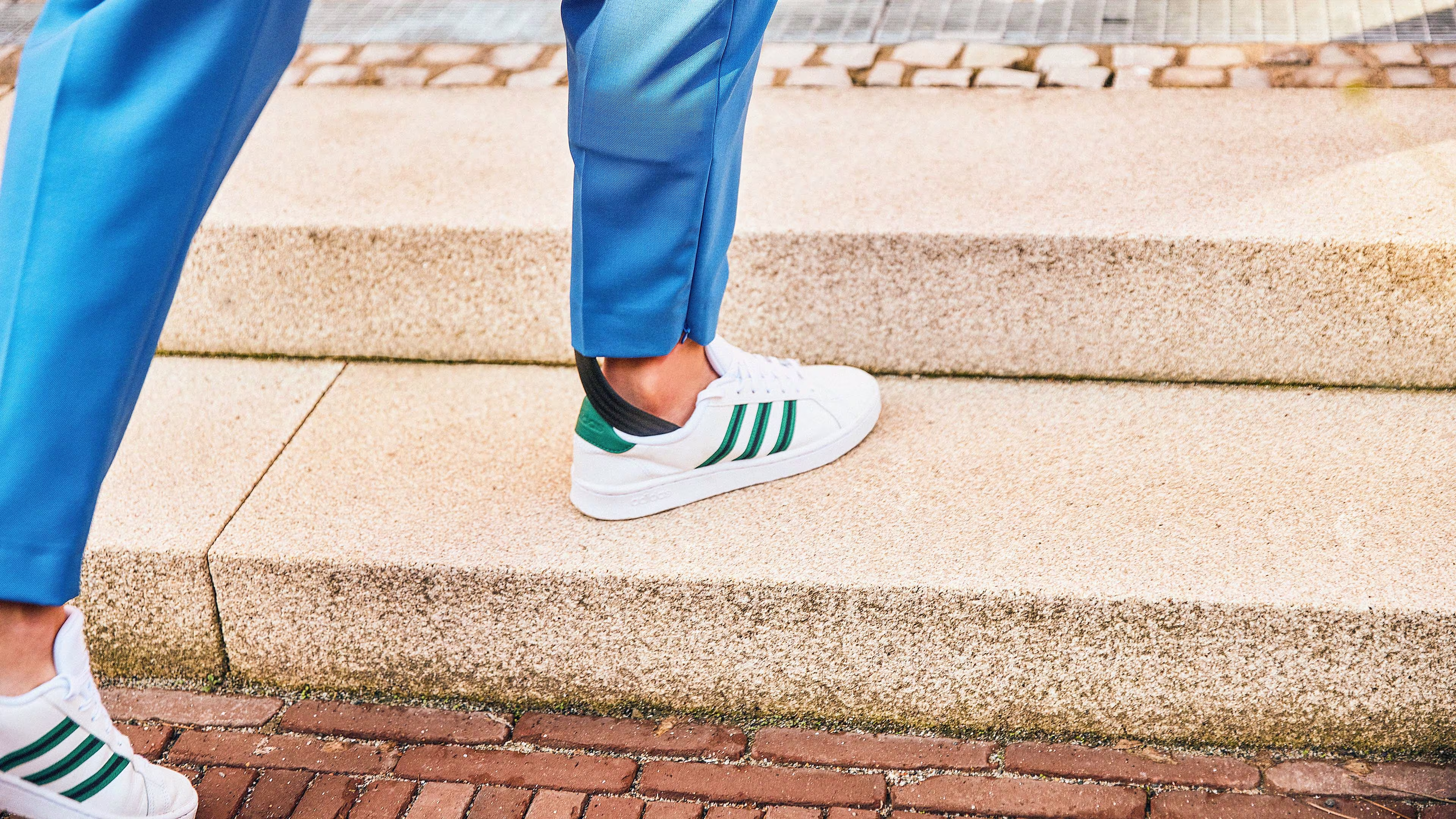 A woman with an orthosis walks up steps.
