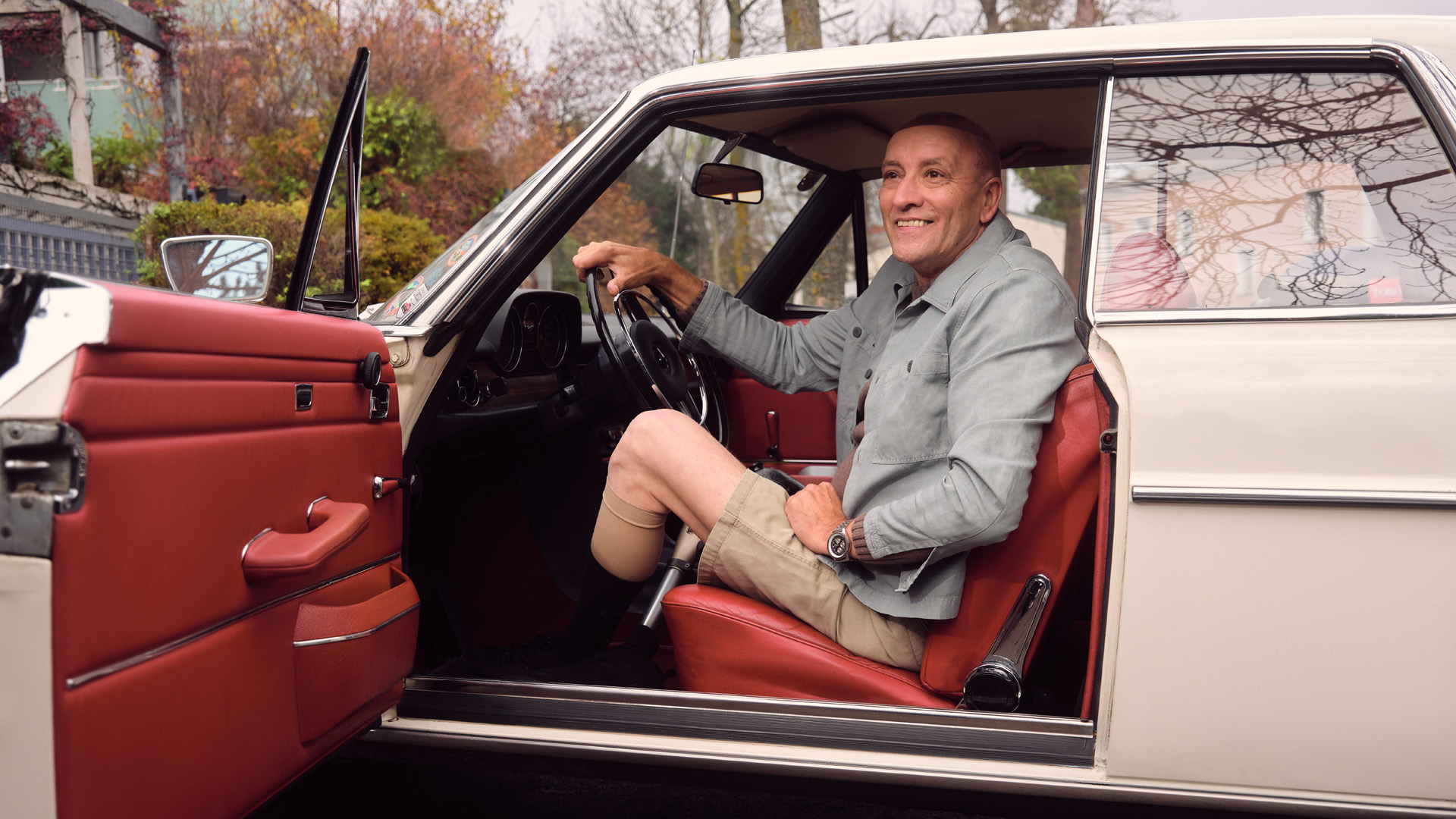 An elderly man sitting in his car and wearing his Ottobock Kenevo.