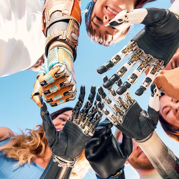 A group of prosthetic hand users standing in a circle placing their prosthetic hands including the bebionic from Ottobock in the middle on top of each other.