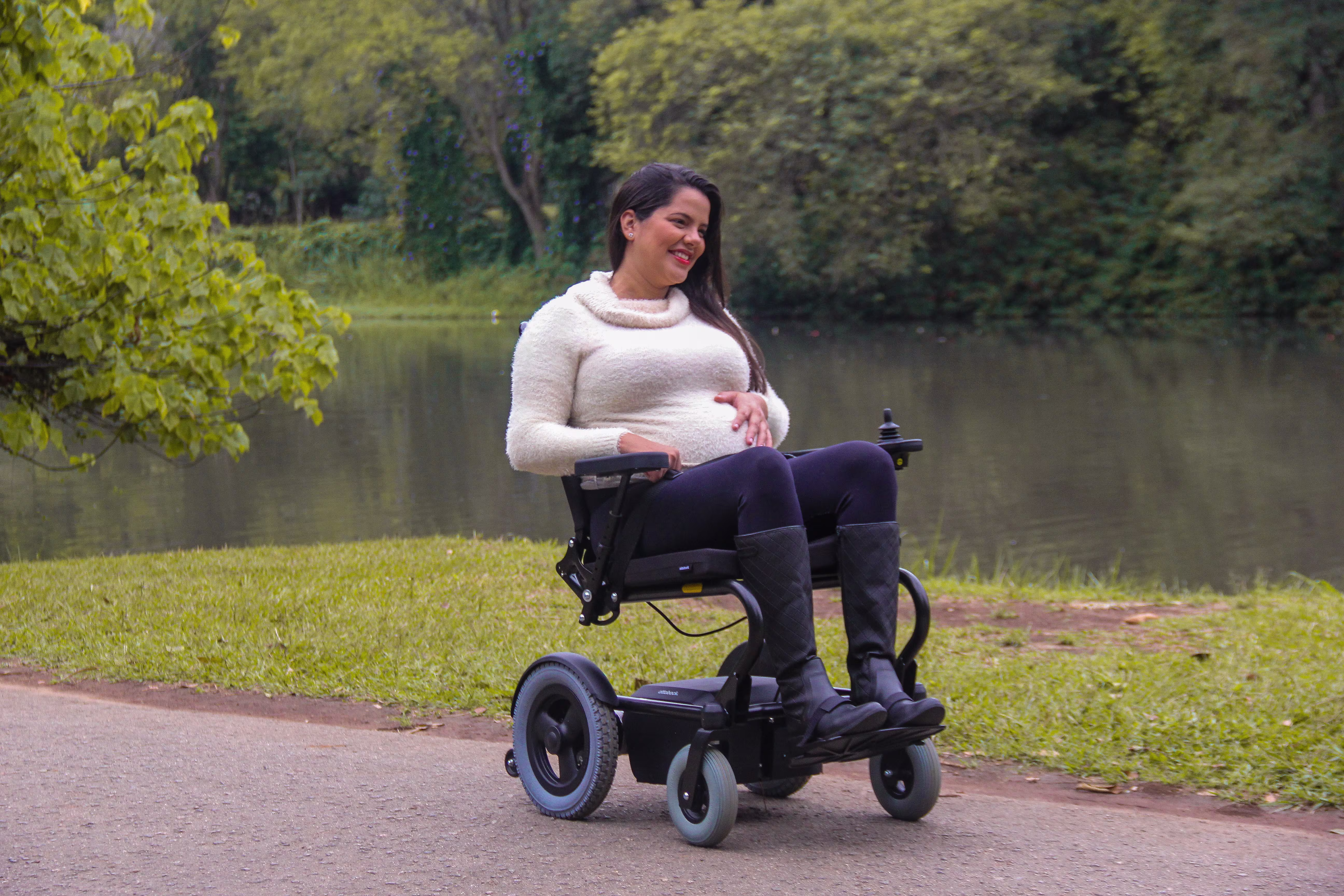A woman and a man in Ottobock wheelchairs at a harbor in front of a small boat that is lifted up