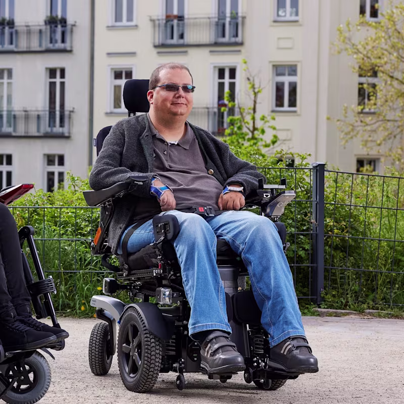 Power wheelchair user Tobias is in Ottobock B7, relaxing outside at a park in Berlin and enjoying the sun.