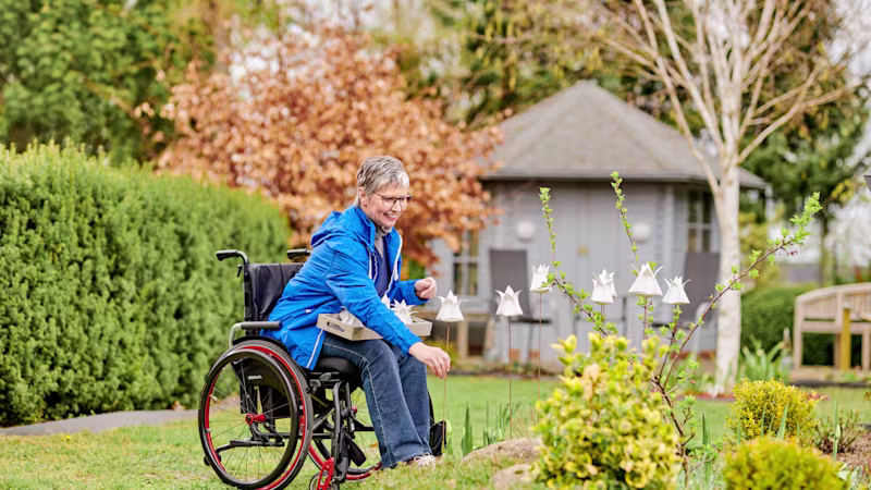 Eine Frau im Avantgarde-Rollstuhl von Ottobock genießt die Gartenlandschaft.