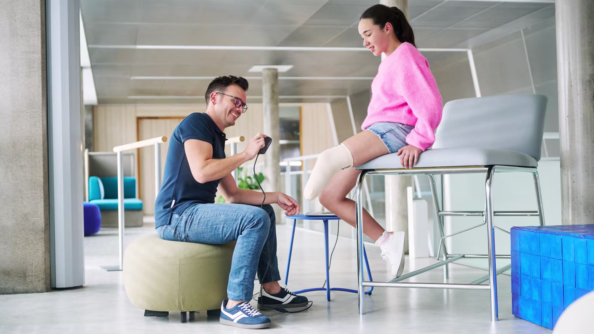 A patients is sitting on a chair and trying an Ottobock liner