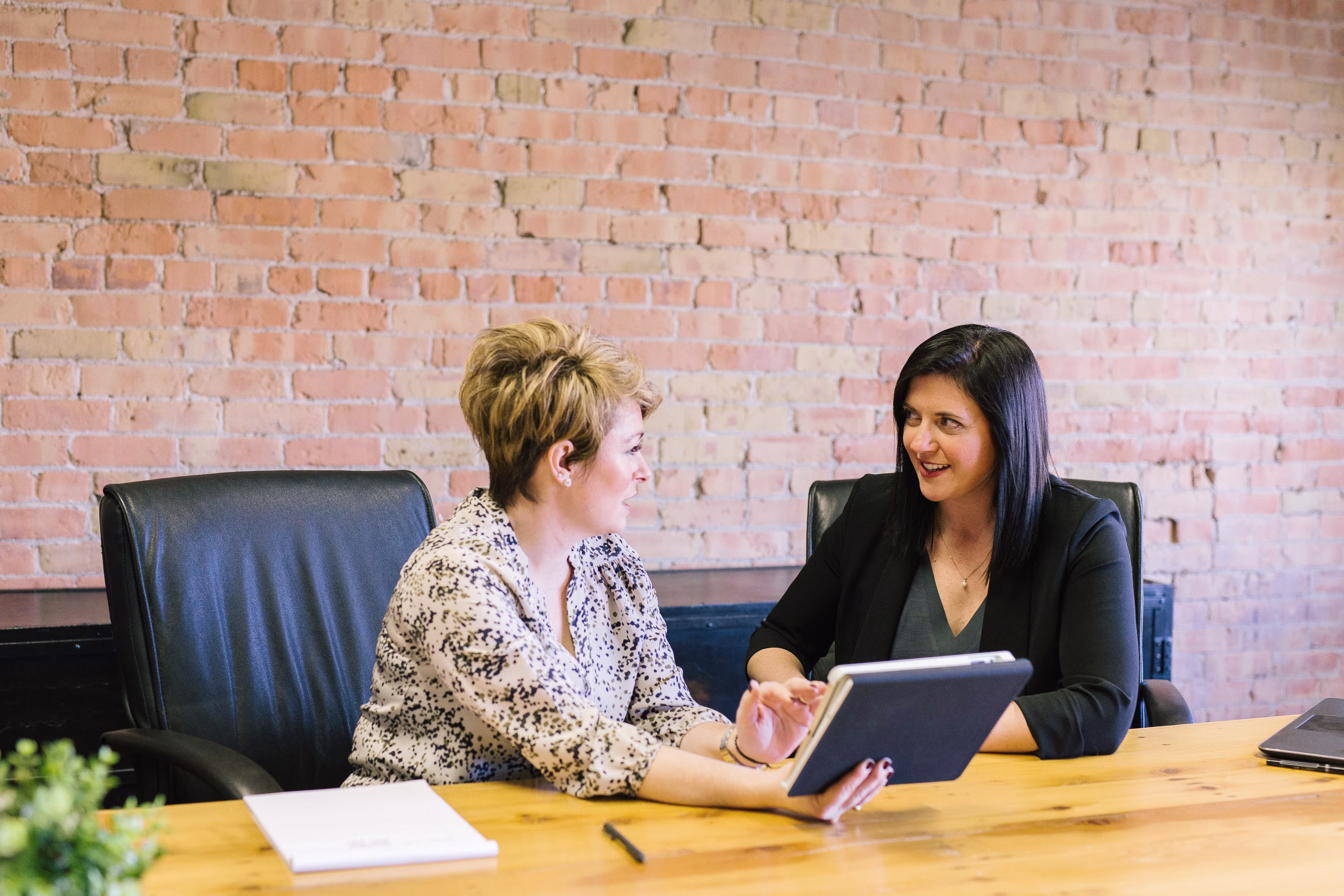 Two colleagues conversing in a meeting room