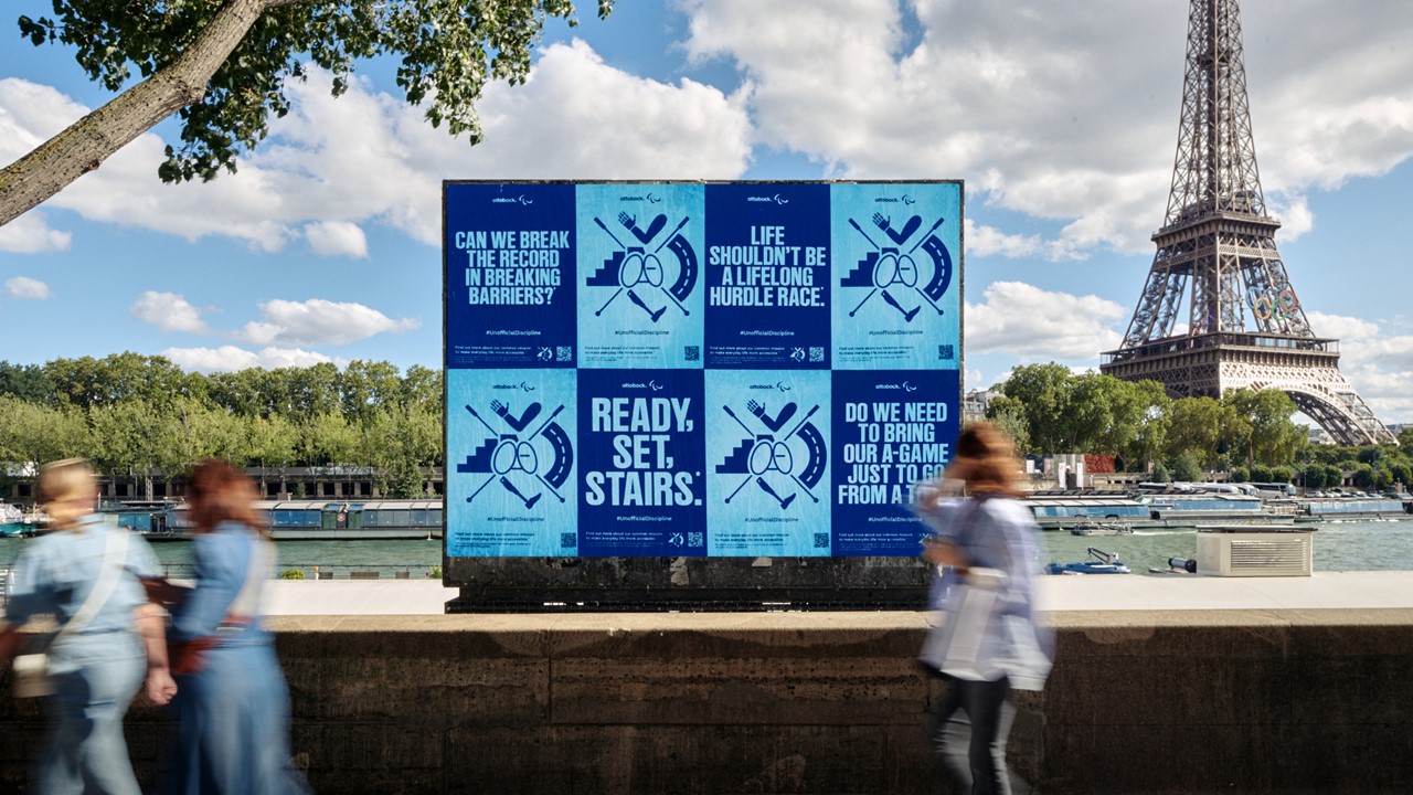 Posters van de Ottobock Unofficial Discipline -campagne op een panel op de voorgrond van de Eiffeltoren in Parijs