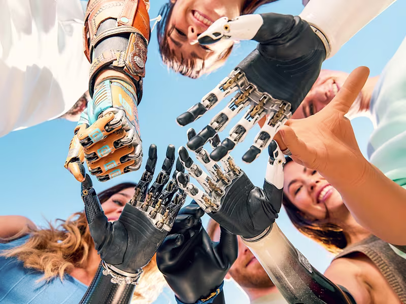 Various Ottobock artificial arm users joining hands in a cirlce