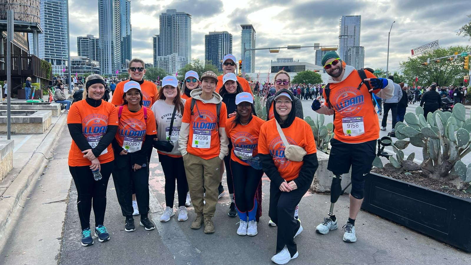 Ottobock employees wearing Limb Loss & Limb Difference Awareness Month branded orange shirts while attending the Statesman Capitol 10,000 in Austin, Texas