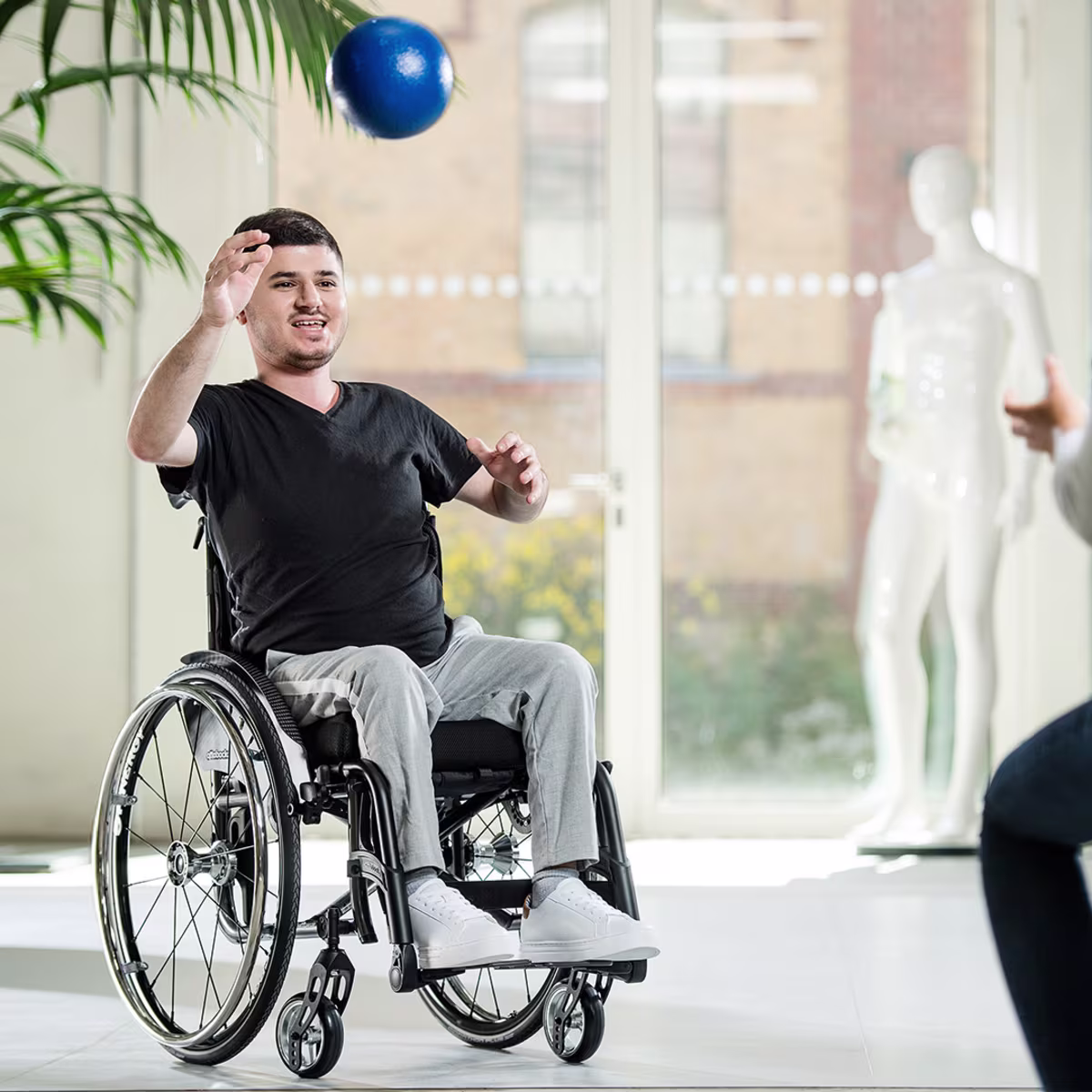 Auf dem Bild sieht man einen Nutzer des Avantgarde Rollstuhls der einen Ball wirft.