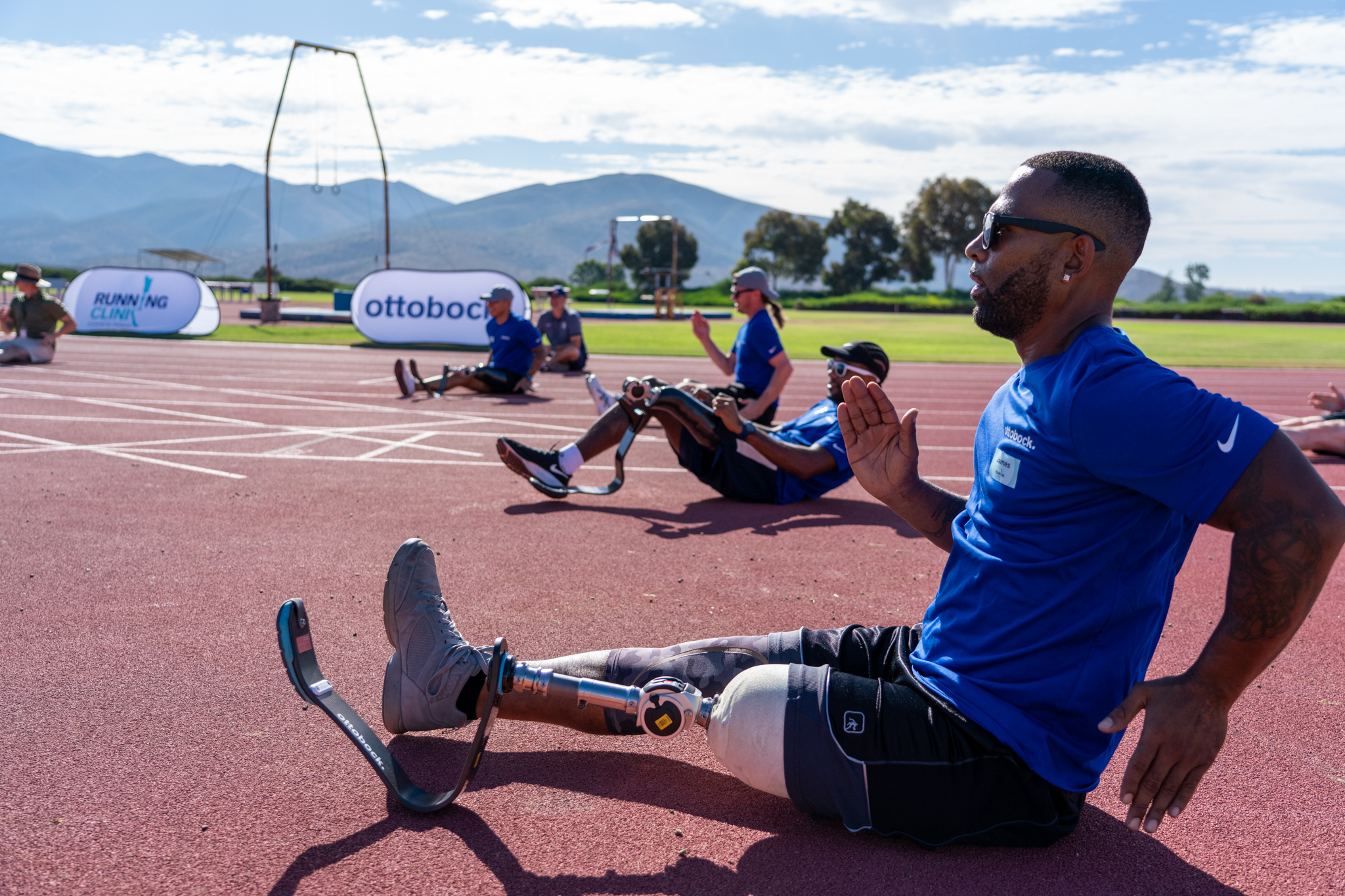 A group of amputees stretching on a running track to prepare for the Ottobock North America Running Clinic