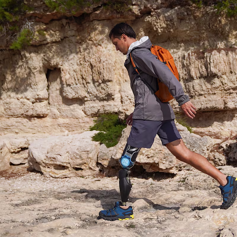 A male user walks over rocky ground with his Ottobock Evanto prosthetic foot.Ein männlicher Anwender geht über einen steinigen Untergrund mit seinem Ottobock Evanto Prothesenfuß.