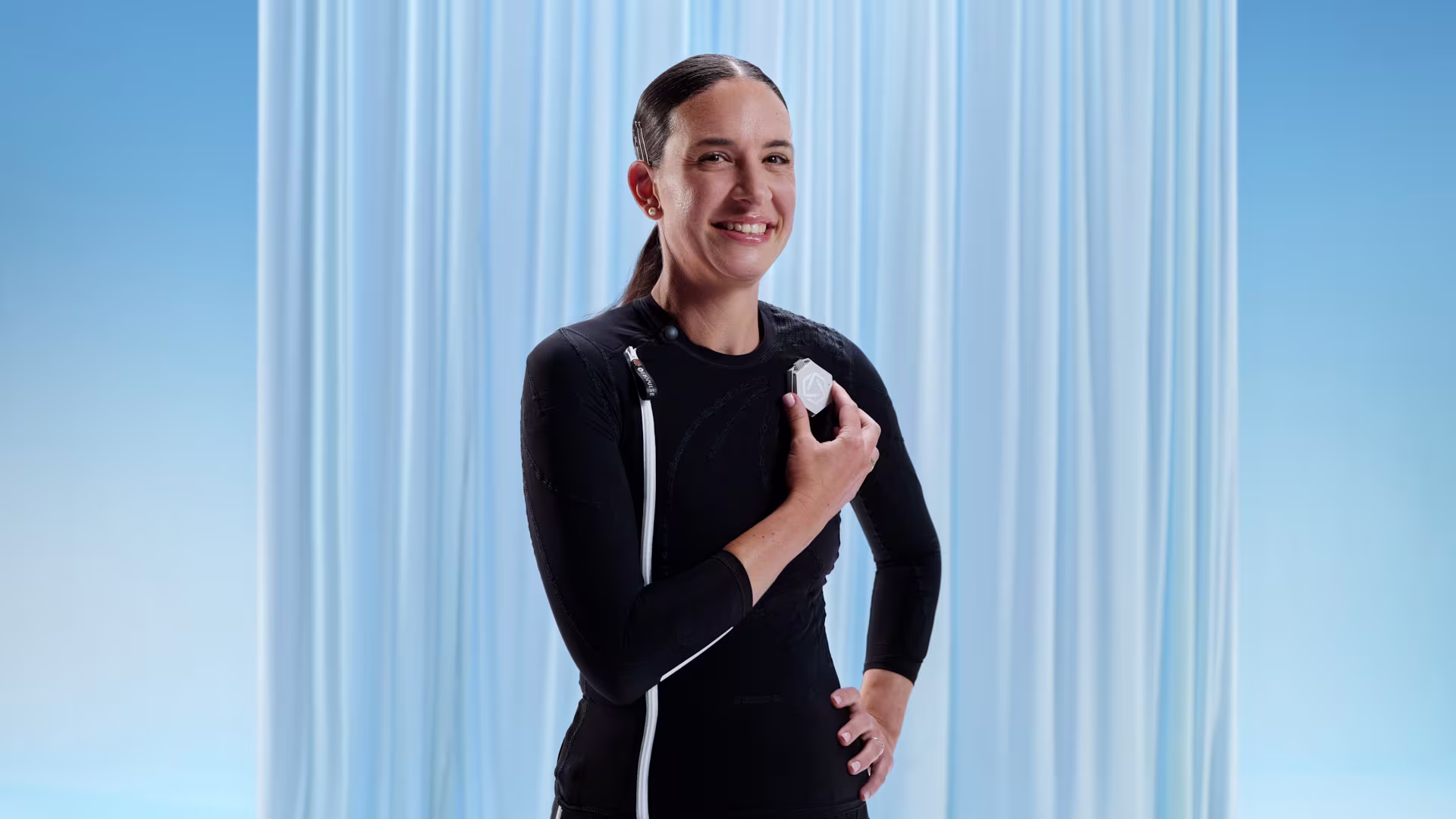 Ottobock user Jacqueline holds the exopulse suit control unit.