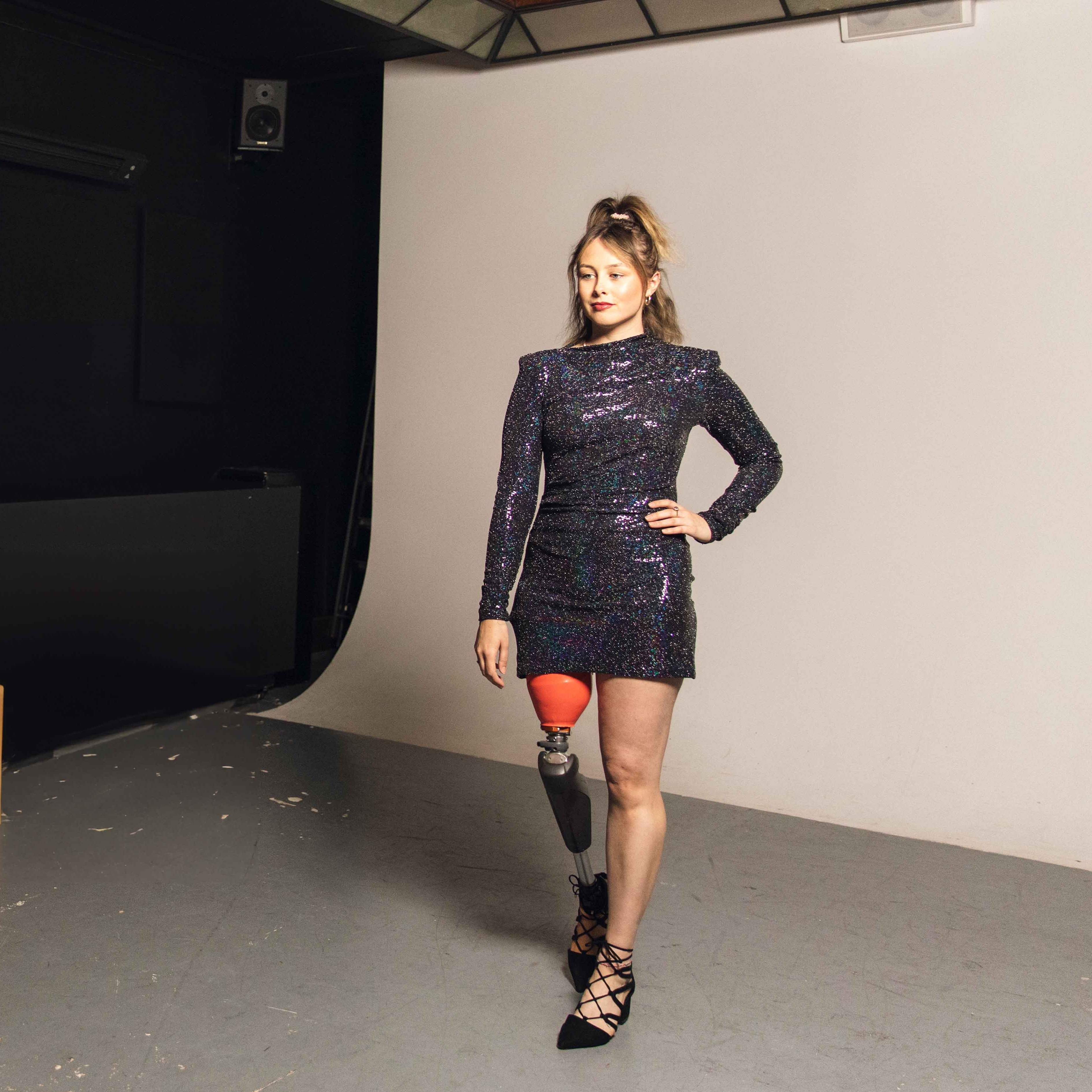 C-Leg user Sarah wearing a black dress posing on a modelling shoot. 
