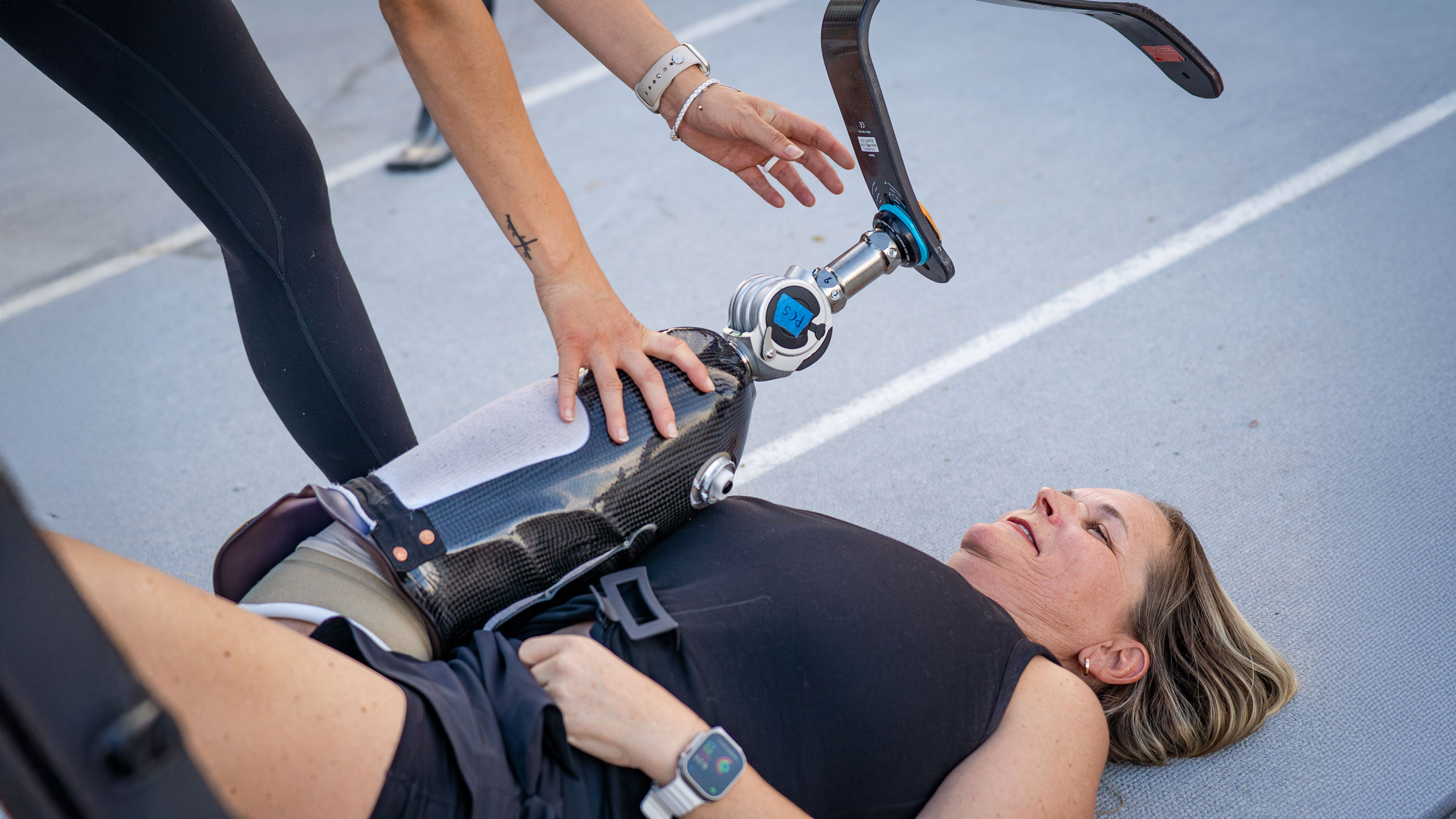 A prosthetic leg user getting assistance while stretching 