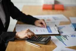 rekenmachine en papieren, ondernemer is bezig met belasting berekenen