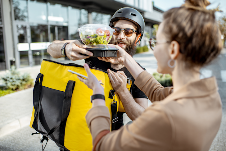 MKBSD - maaltijdbezorger overhandigt eten aan vrouw