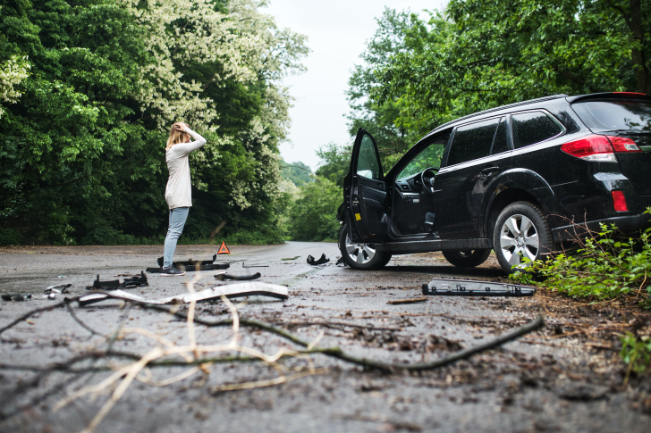 young-woman-standing-by-the-damaged-car-after-a-ca-SHE6YK7