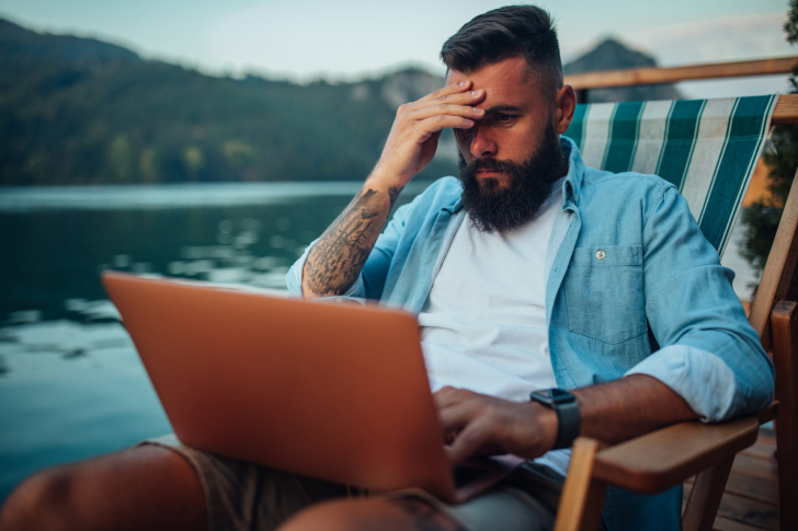 terugroepen-vakantie-man-laptop-buiten-stoel-hangstoel