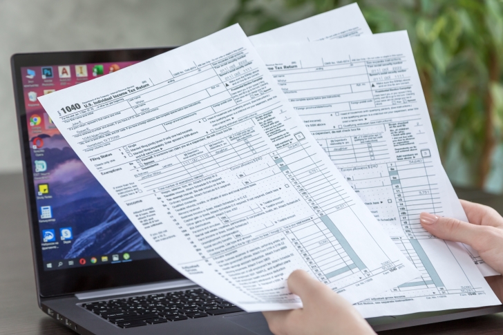 tax-form-1040-us-in-female-hands-on-laptop-background-american-form-tax-taxes-usa-earnings-paperwork t20 2wQ0r0
