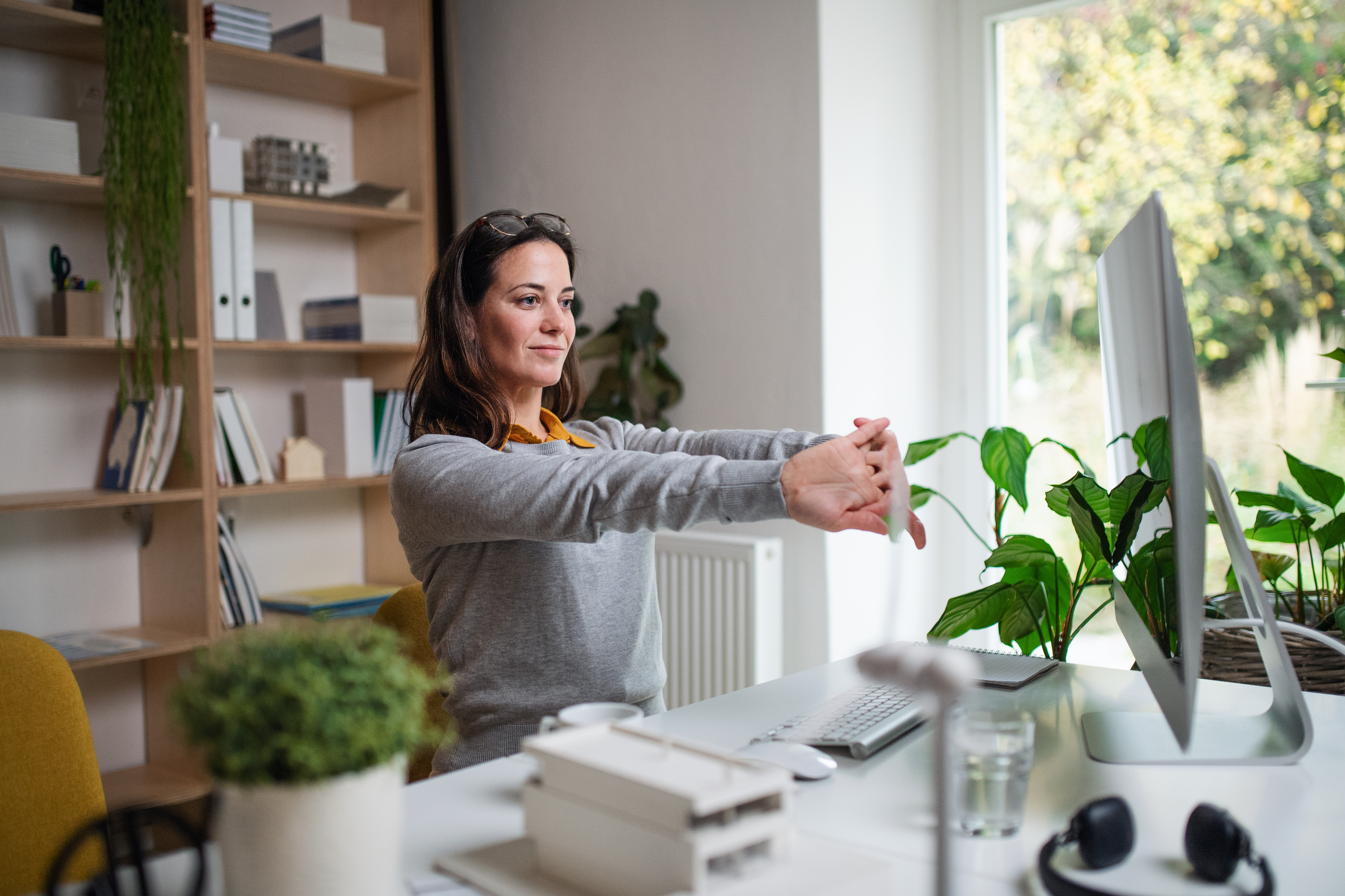 Mujer en oficina decorada con plantas trabajando