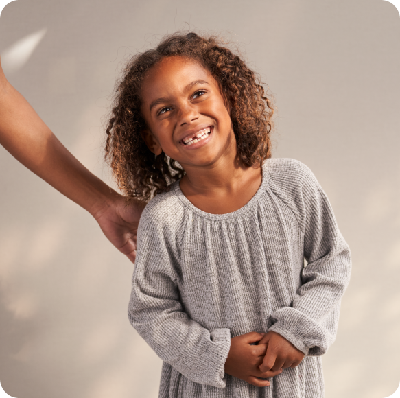 A little girl smiling at the camera.