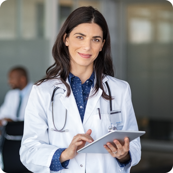 A female doctor smiling at the camera holding a tablet.