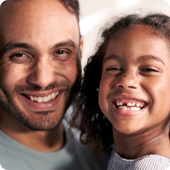 A father and daughter smiling.