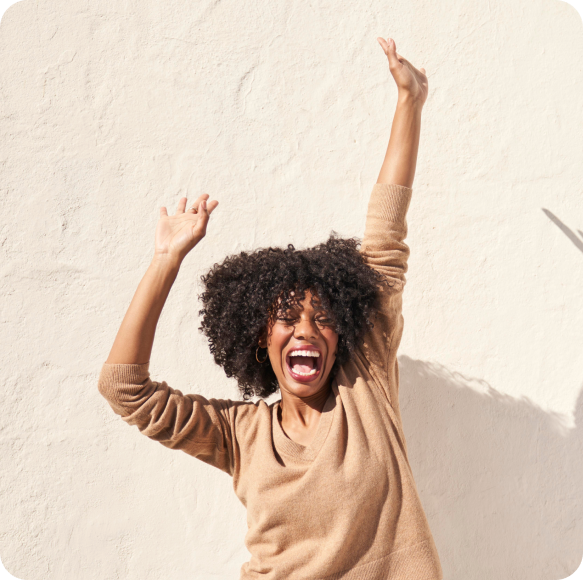 A lady jumping for joy outside.