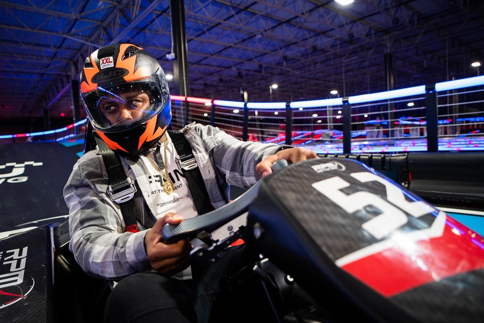 man wearing helmet racing go karts in a lesson environment