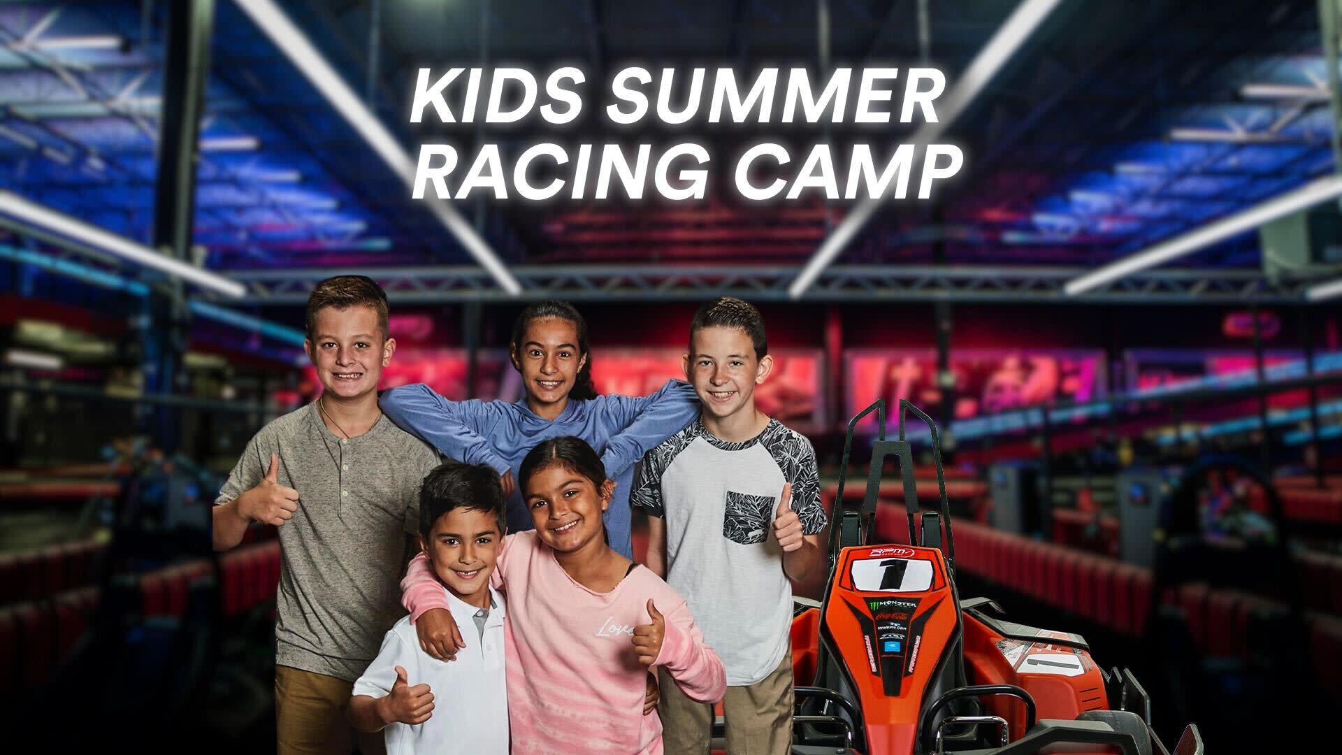 A group of diverse children at a go-kart track smiling and giving thumbs up, with the text "KIDS SUMMER RACING CAMP" displayed above them. The background shows an indoor racing track with colorful lights. An orange go-kart is visible in the foreground.